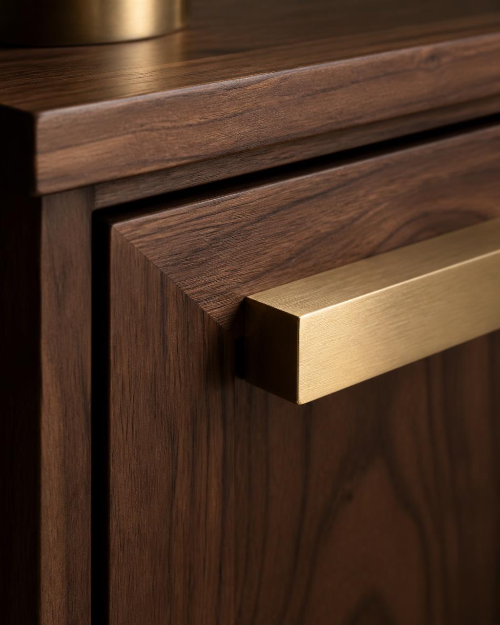 Close-up of brushed brass handle on walnut cabinetry
